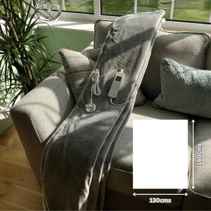 Light grey sherpa heated throw on sofa showing 160x130cms size